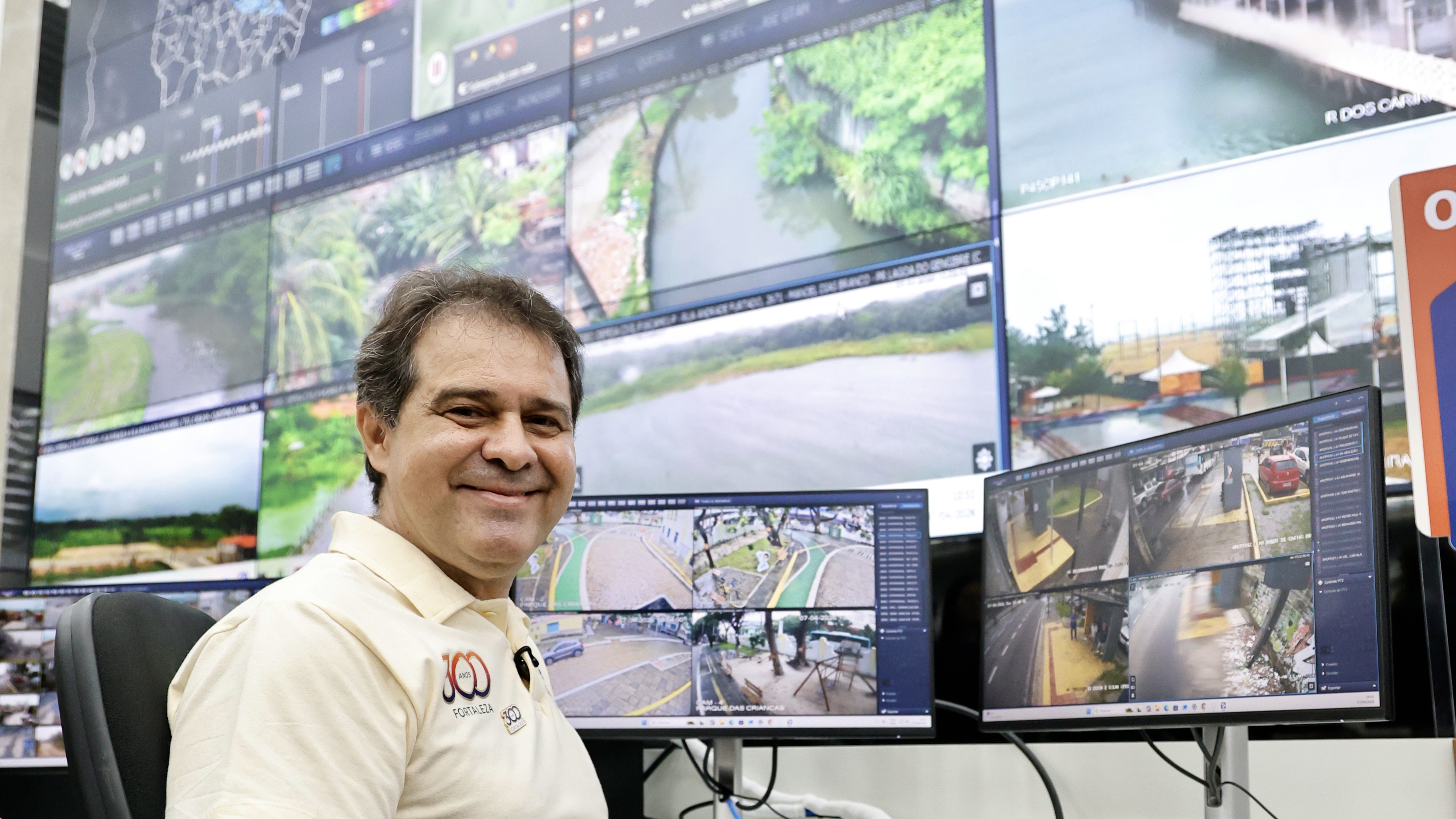 prefeito Evandro posa para a foto na frente no painel com as telas do videomonitoramento
